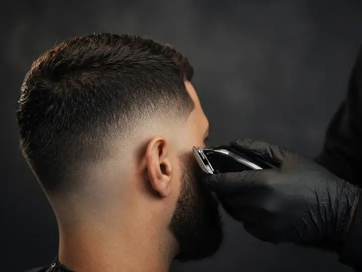 Perfilado de barba con máquina sobre un degradado